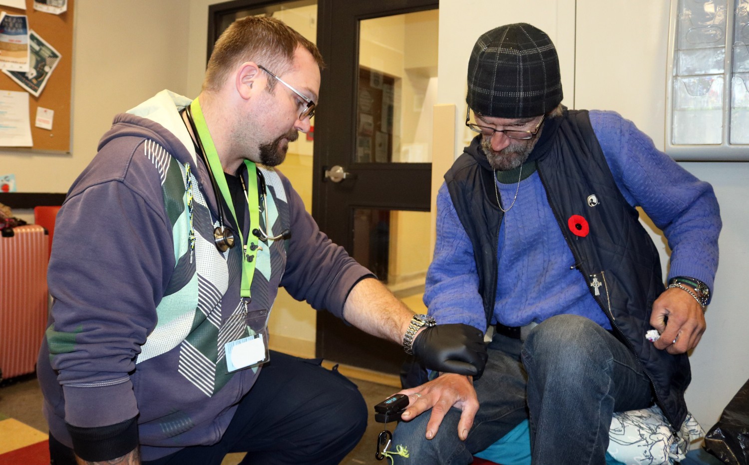 Outreach worker/paramedic Jonathon (left) treating family member Yann